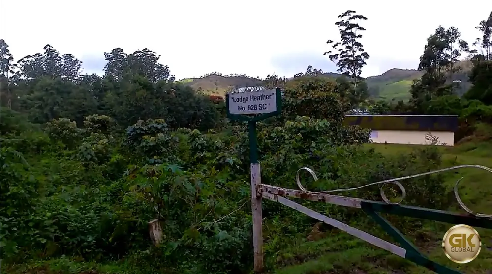 The gate of Lodge Heather on High Range Club Road, Munnar, with a green-framed sign reading Lodge Heather No. 928 SC and the lodge building beyond